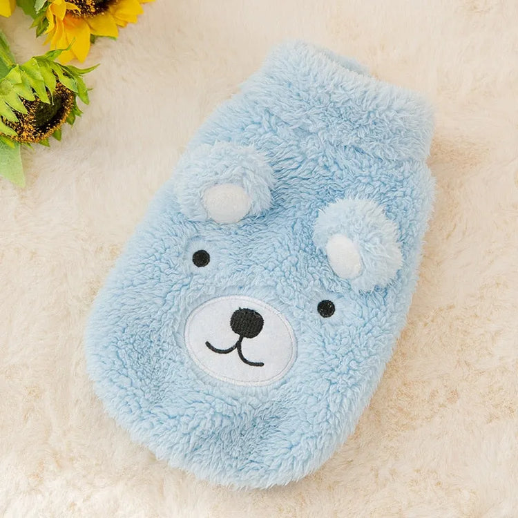 The Dog Face Cute Bear Dog Fur Coat in sky blue, displayed on a fluffy surface.