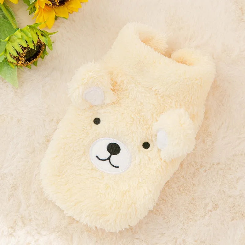 The Dog Face Cute Bear Dog Fur Coat in yellow, displayed on a fluffy surface.