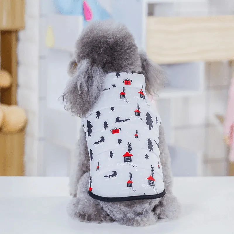 Back view of a poodle wearing a white dog snow suit with red and black winter patterns