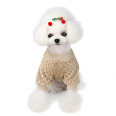 White fluffy dog wearing a beige dog face shirt with a cartoon dog patch on the chest, sitting and facing forward