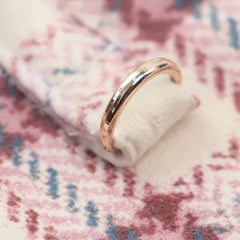 Close-up of the ring detail on a pink plaid dog coat with white fleece lining