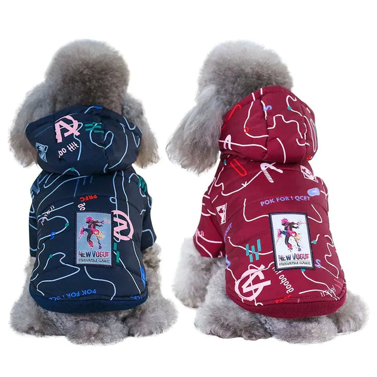 Back view of two dogs wearing designer dog jackets, one in red and the other in navy blue, with colorful abstract patterns and a 'New Vogue' patch.