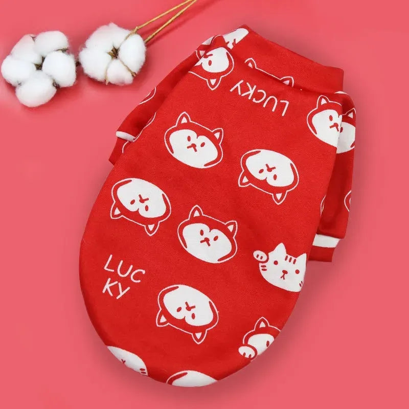 Designer Dog Coat in red with cat faces and 'Lucky' text, perfect for adding a vibrant and charming touch to your dog's wardrobe.