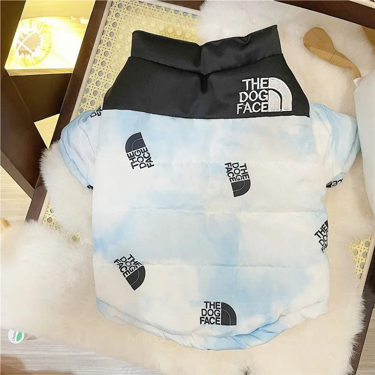 Light blue dog puffy jacket with black collar and 'The Dog Face' logo pattern