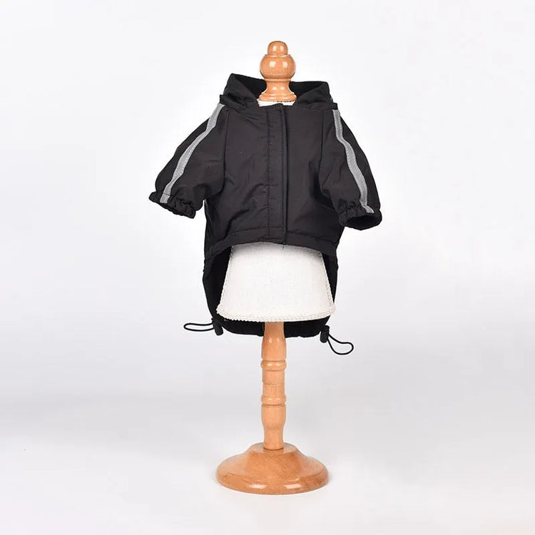 Black dog raincoat with hood displayed on a mannequin, perfect waterproof apparel for pets.