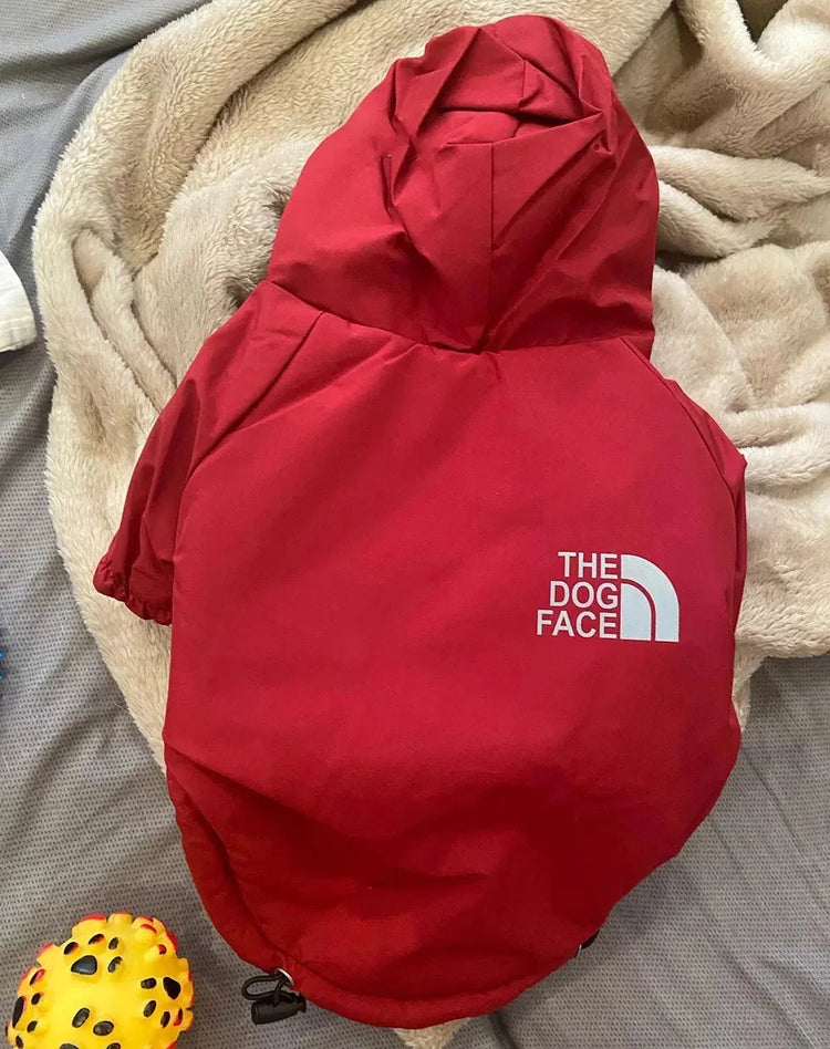 Red "The Dog Face" raincoat for dogs, highlighting durable and stylish waterproof dog apparel.