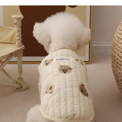 White poodle wearing an embroidered dog sweatshirt with bear design, back view