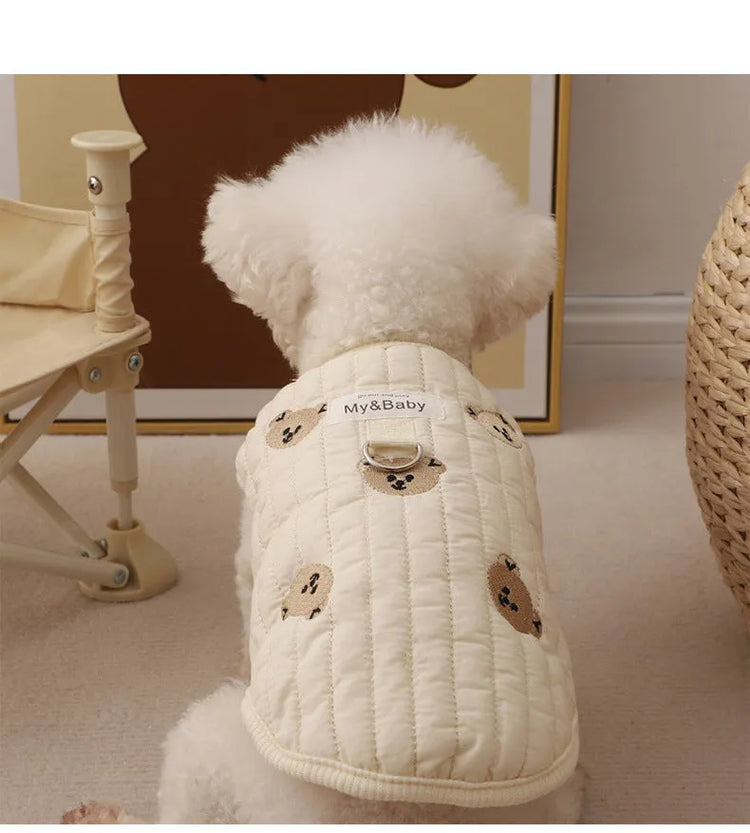 White poodle wearing an embroidered dog sweatshirt with bear design, back view