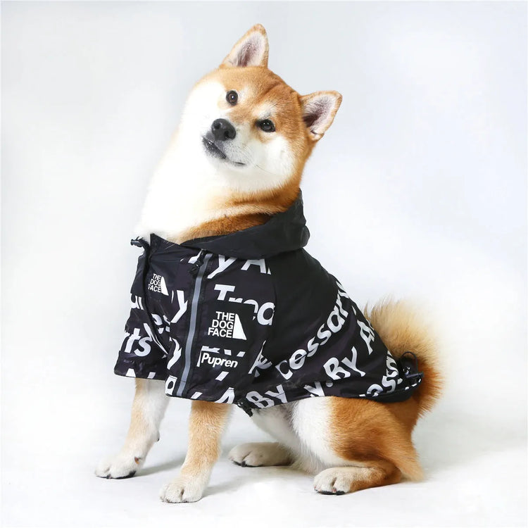 Shiba Inu dog sitting happily in a black "The Dog Face" hoodie, showcasing fashionable dog apparel.