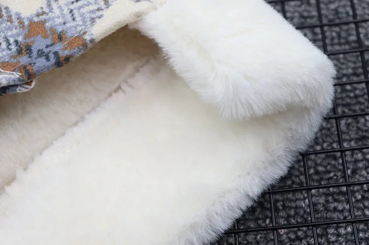 Close-up of the soft white fleece lining inside a plaid dog coat