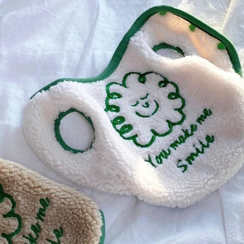 Close-up of cream and brown embroidered dog shirts with green smiling face design and 'You make me smile' text, showcasing Embroidered Dog Shirts."