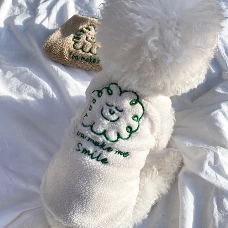 Dog wearing a cream embroidered shirt with a green smiling face design and 'You make me smile' text, an excellent choice for an Embroidered Dog Shirt."